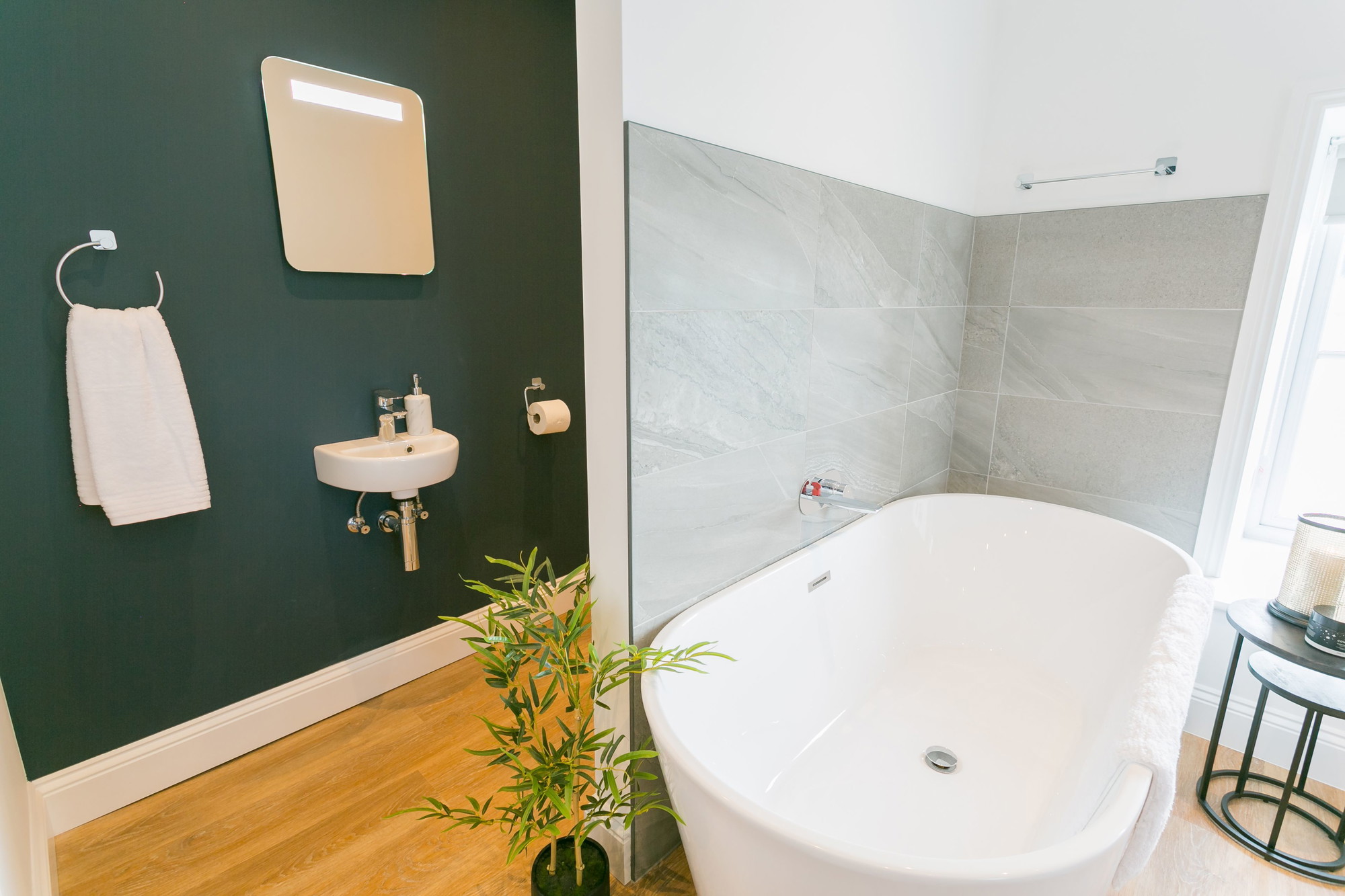 Freestanding bath beside a window with watery views