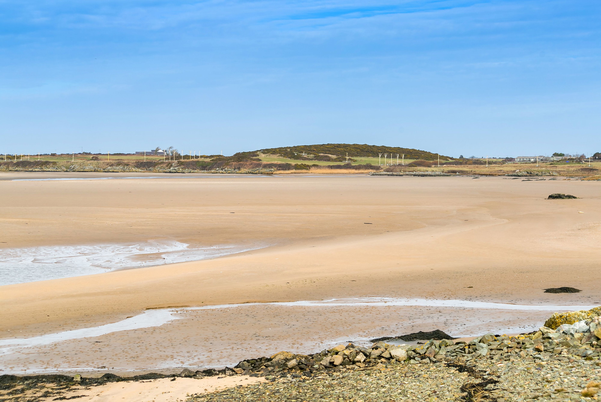 The wide sandy beach at Cymyran at low tide