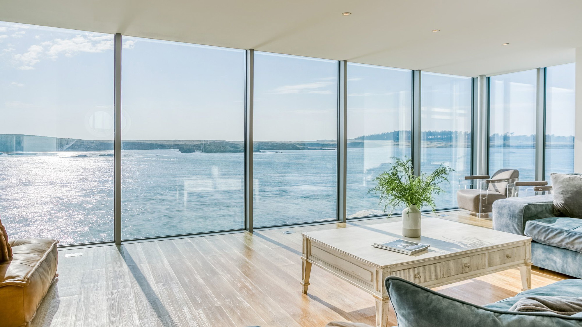 Living area with L-shaped sofa and panoramic windows over the coast